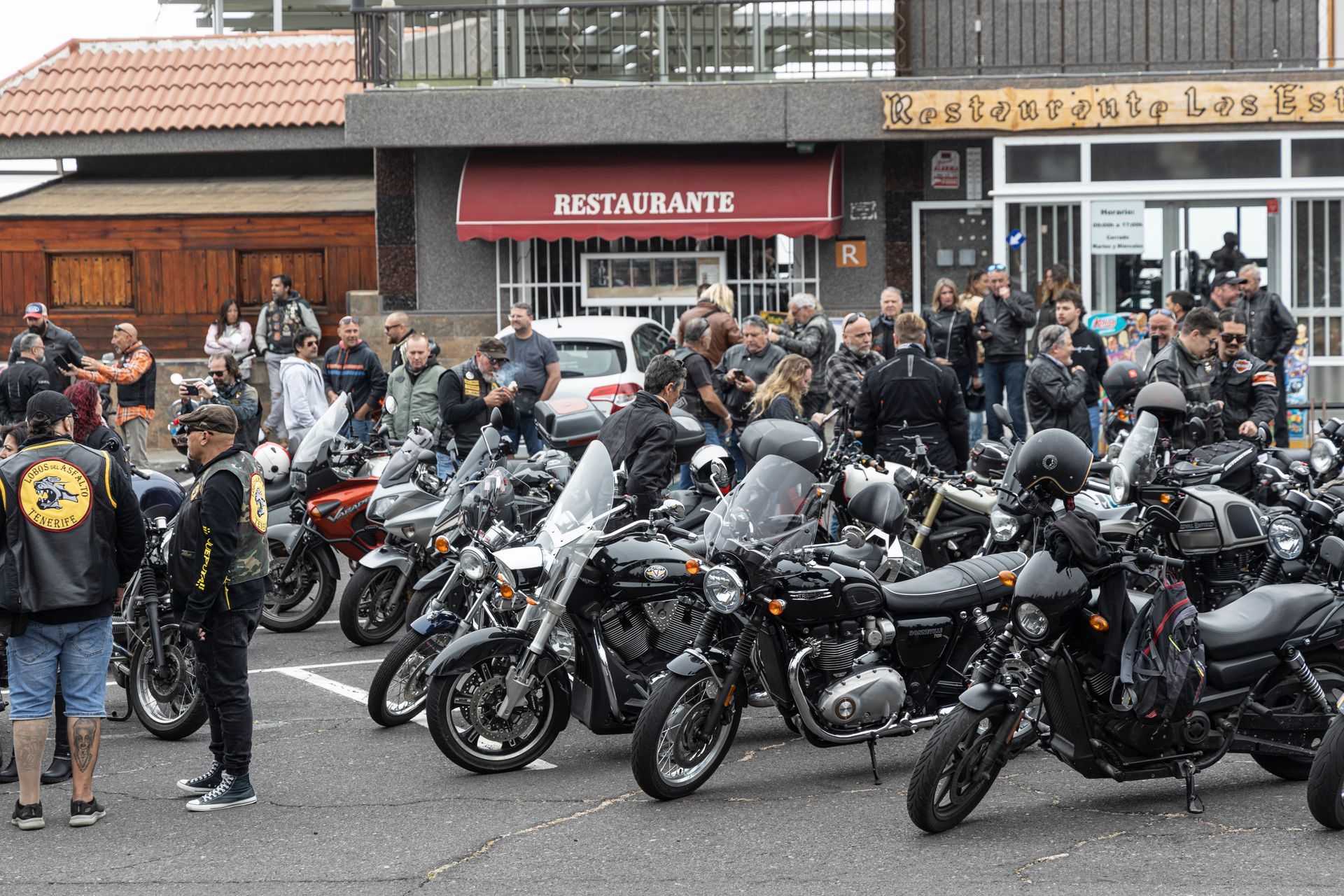 A lot of motorcycles are parked in front of a restaurant