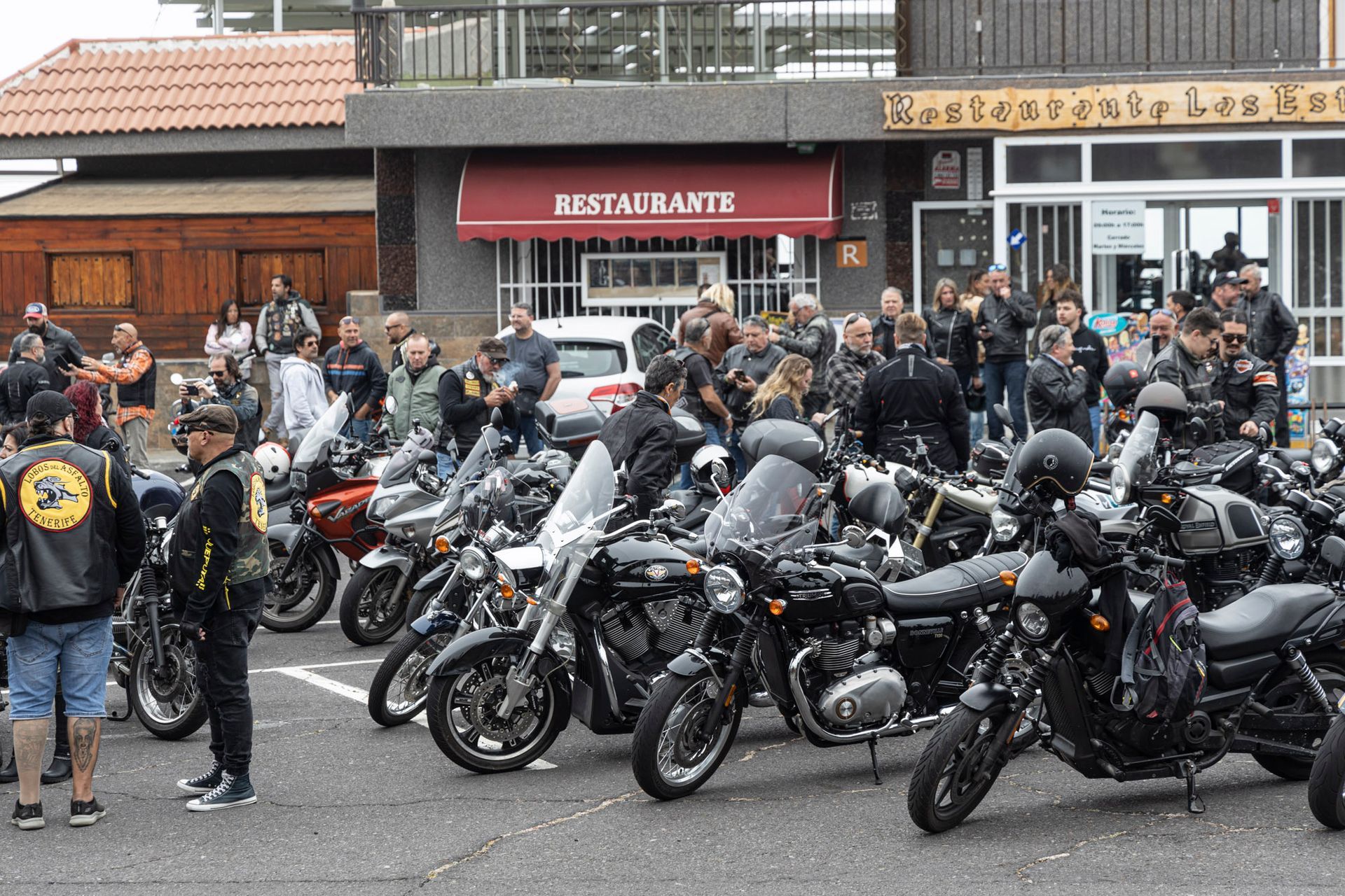 A row of motorcycles are parked in front of a restaurant
