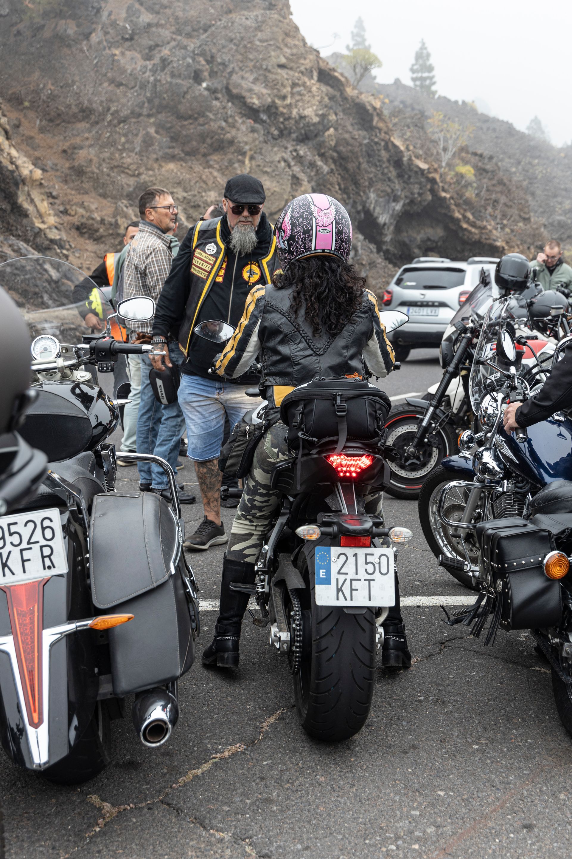 A group of people are riding motorcycles down a road.