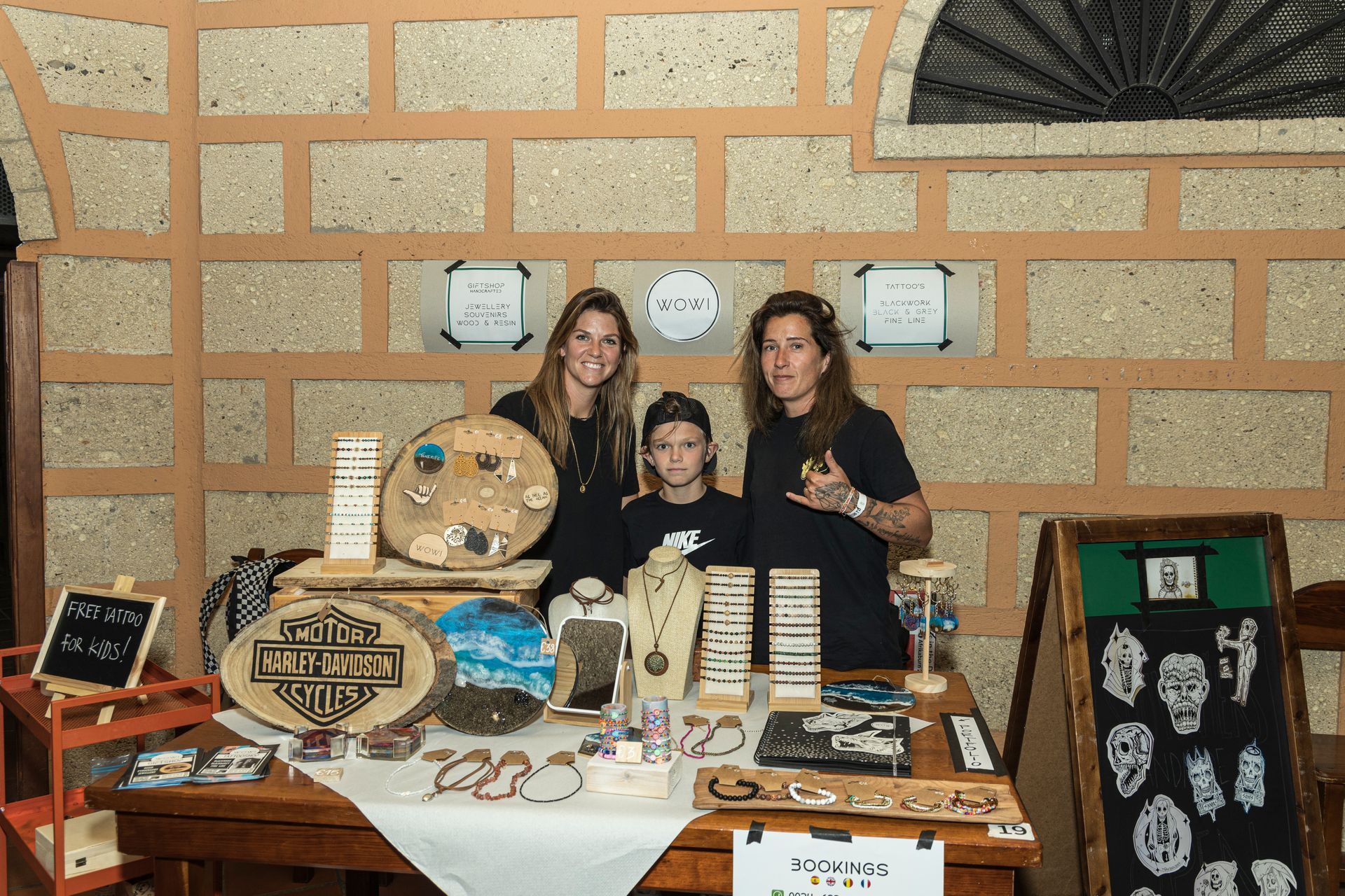 A group of people standing around a table with jewelry on it.