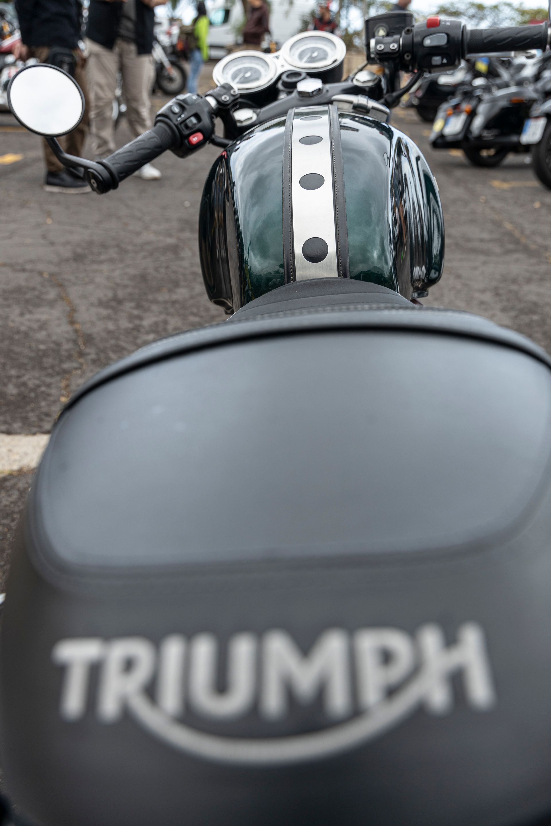 A triumph motorcycle is parked in a parking lot.