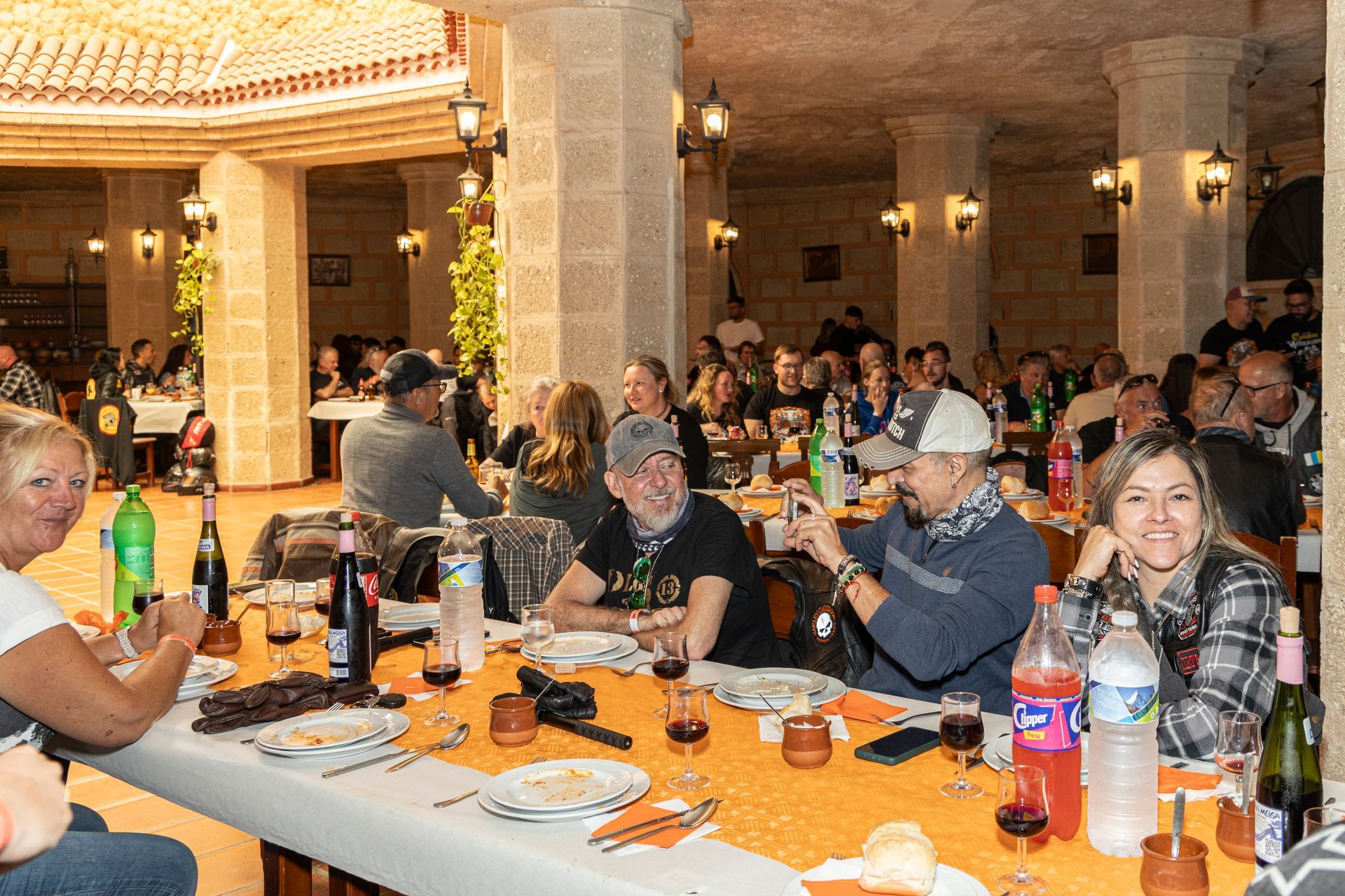 A group of people are sitting at a long table in a restaurant.