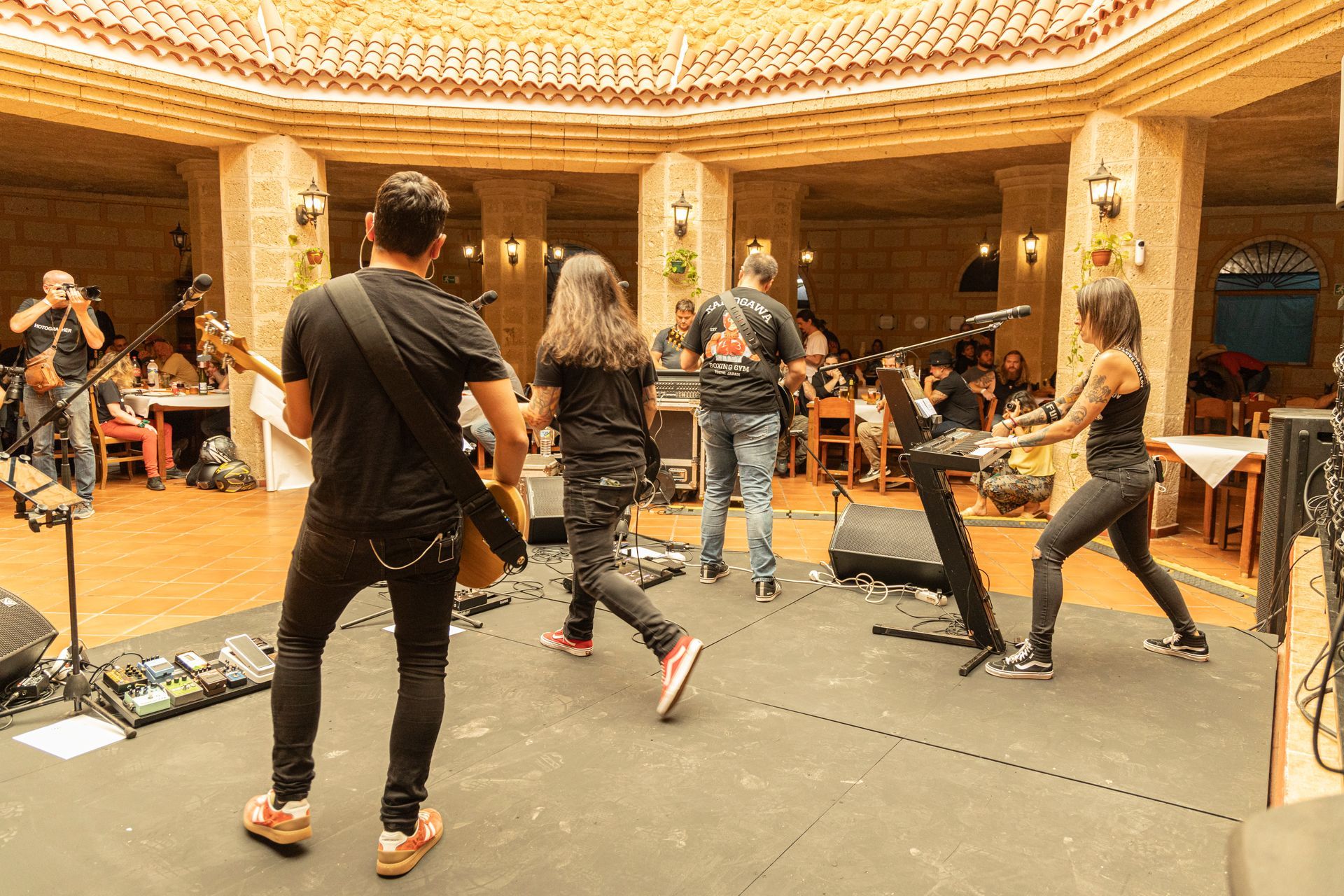 A group of people are playing instruments on a stage in a large room.