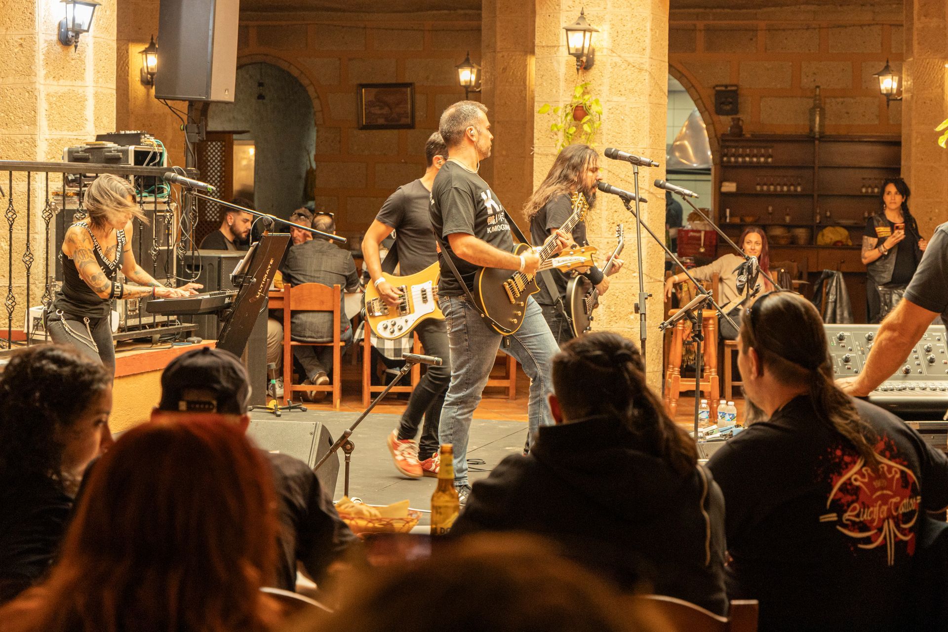 A group of people are watching a band perform on stage