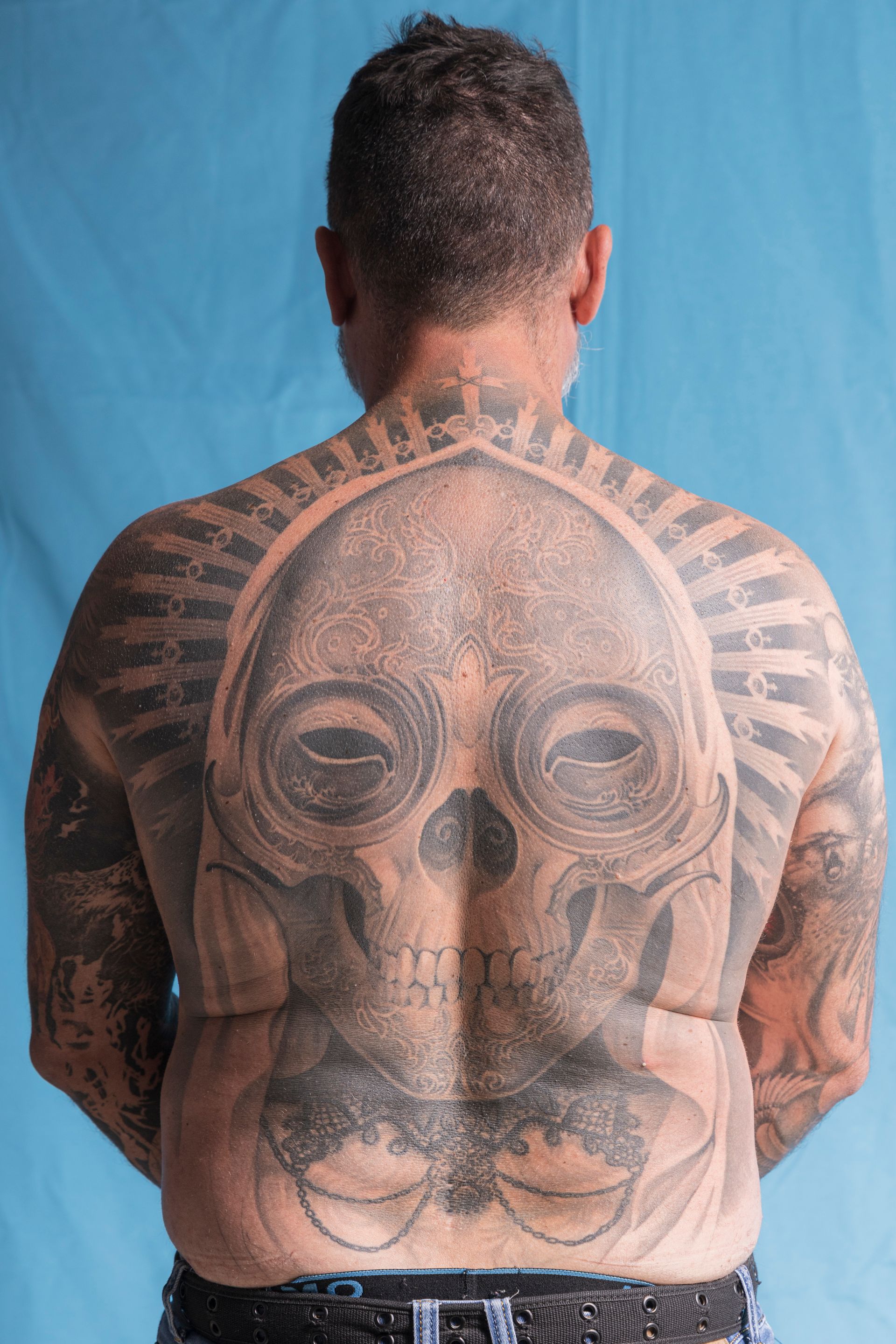 A man with a skull tattoo on his back