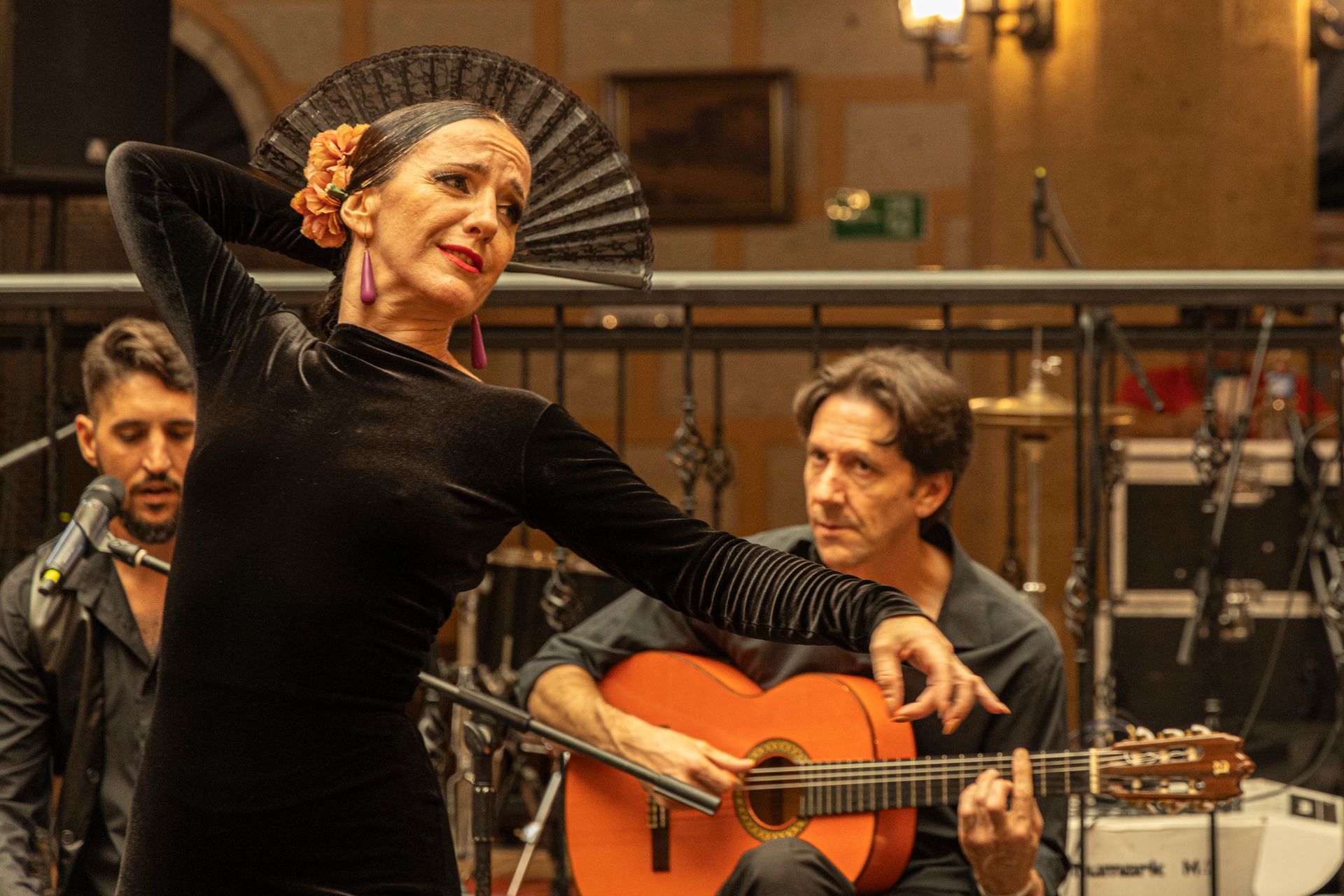 A woman is dancing flamenco while a man plays a guitar.