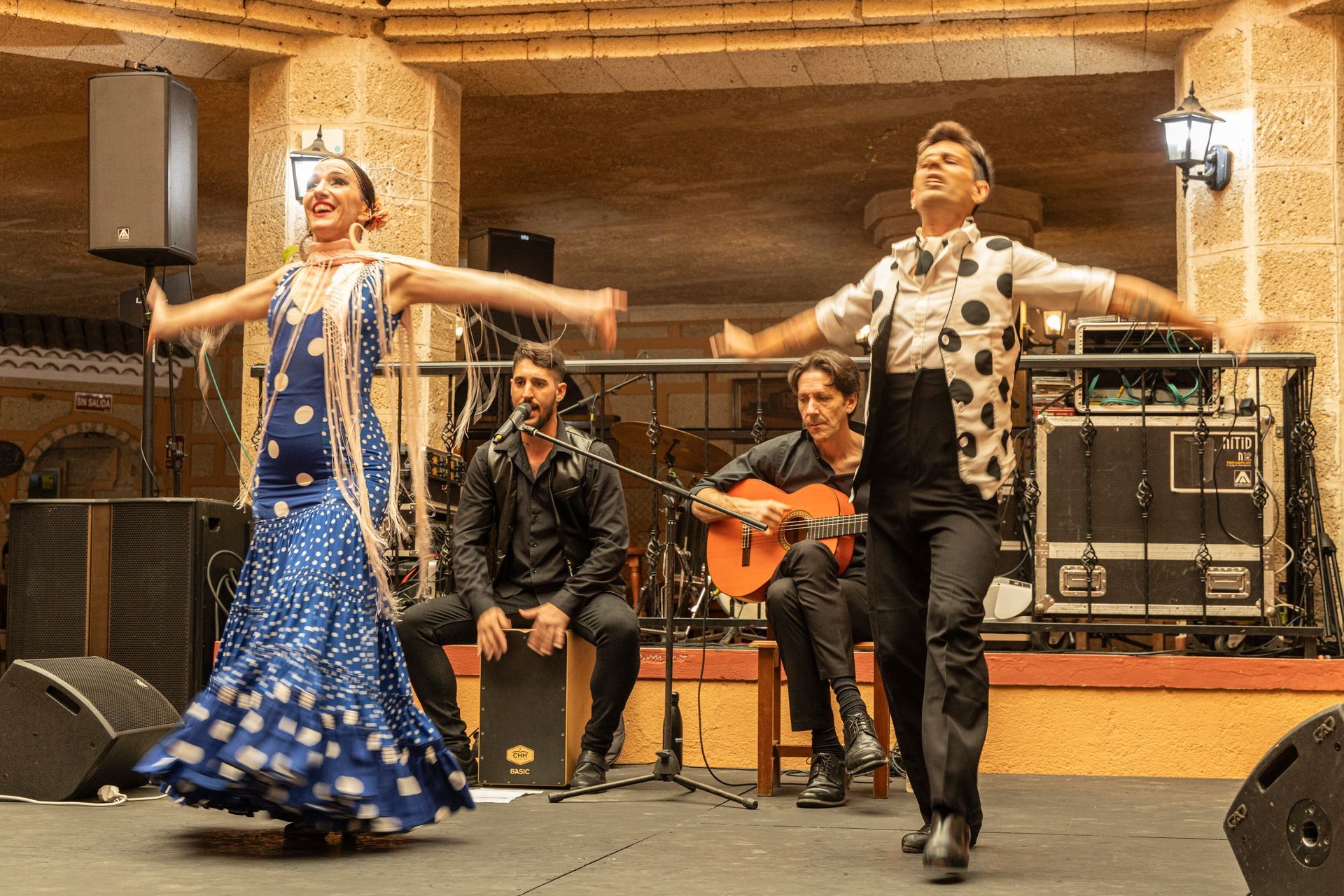 A man is playing a guitar while a woman is dancing on a stage.