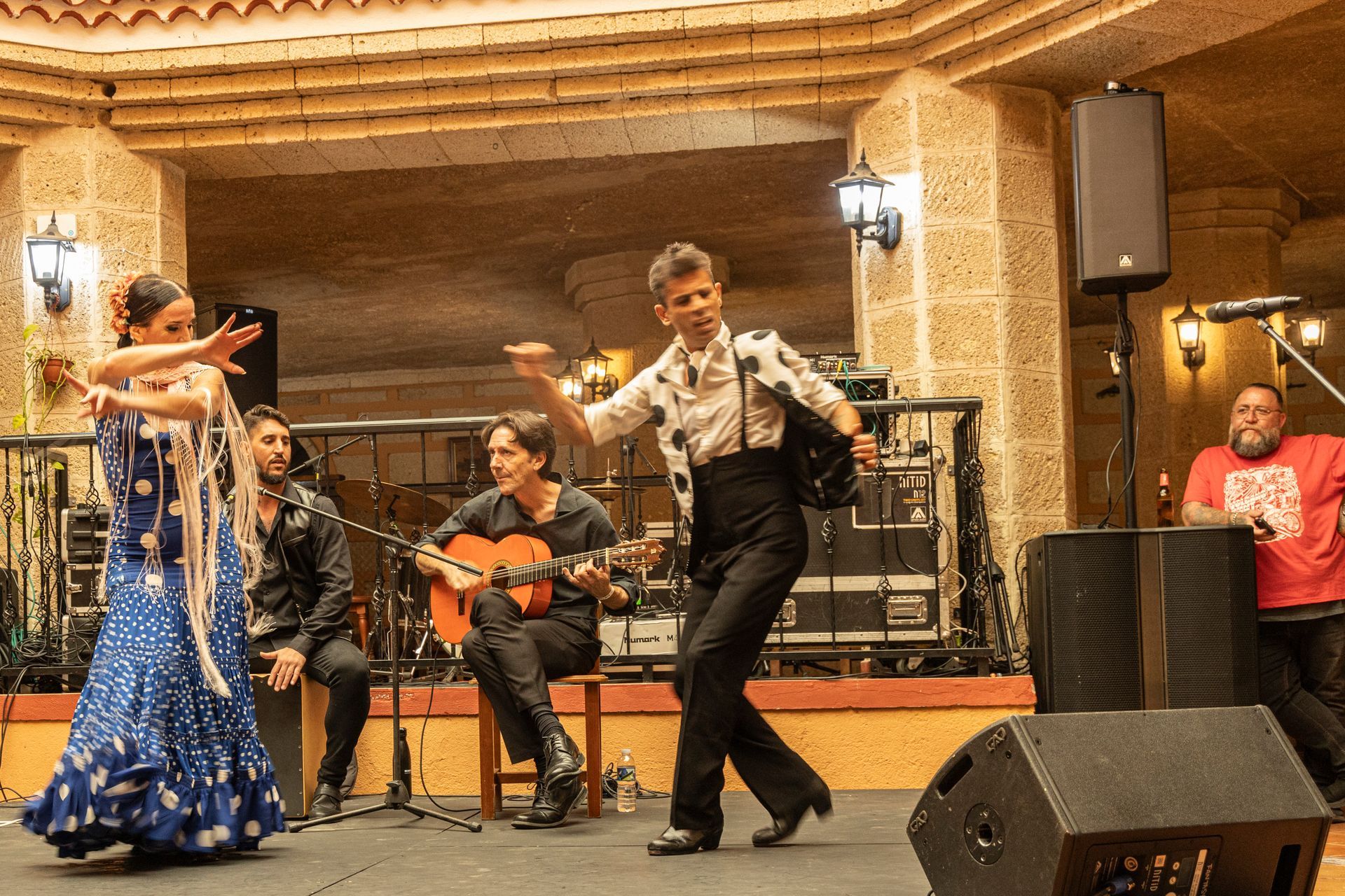 A group of people are dancing and playing guitars on a stage.