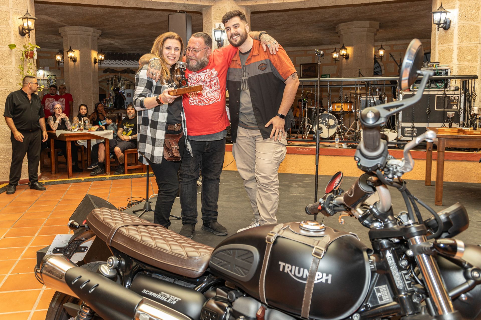 A group of people are posing for a picture in front of a motorcycle.