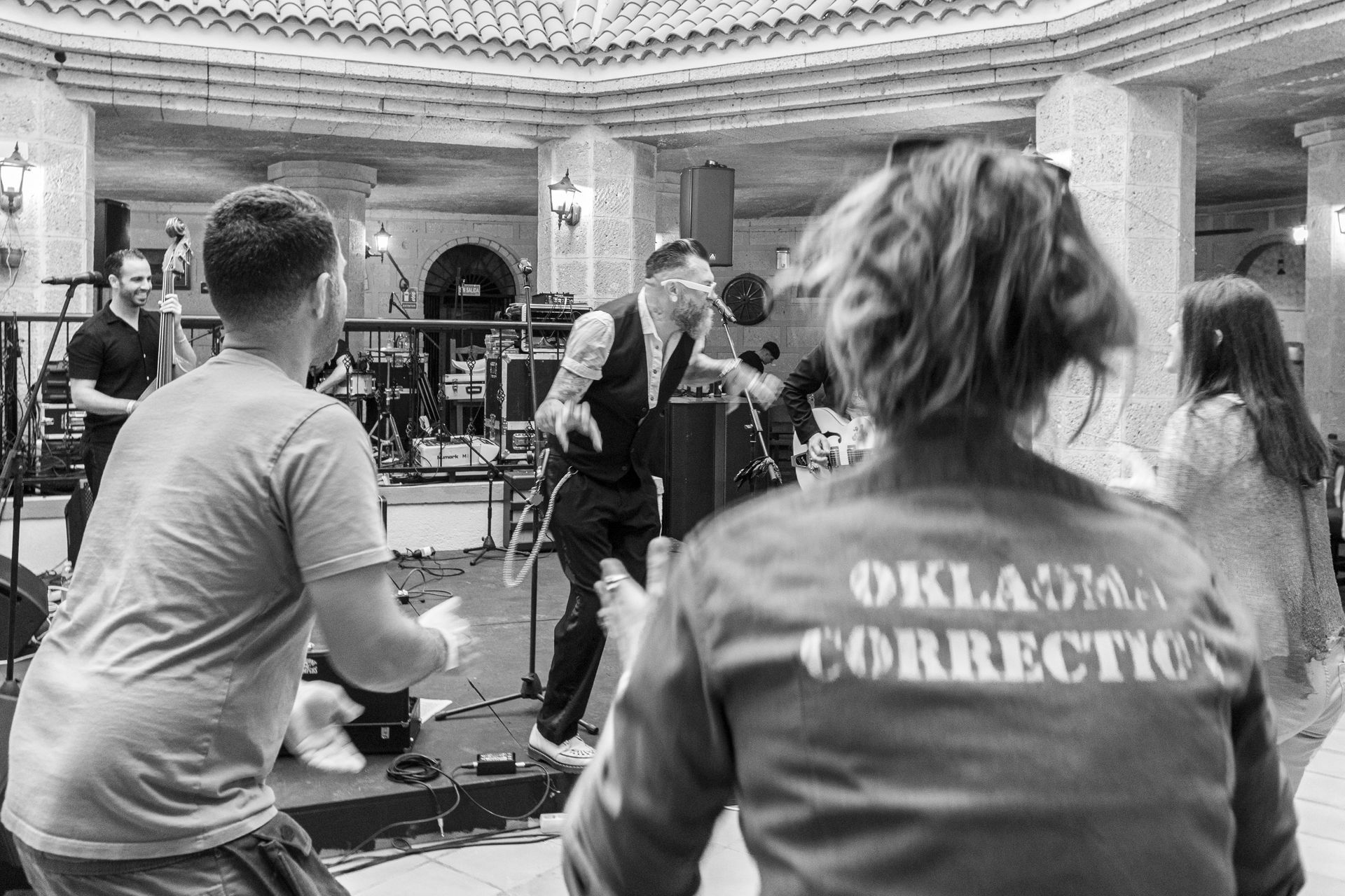 A black and white photo of a group of people dancing in a room.