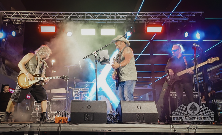 A group of men are playing guitars and singing on a stage.