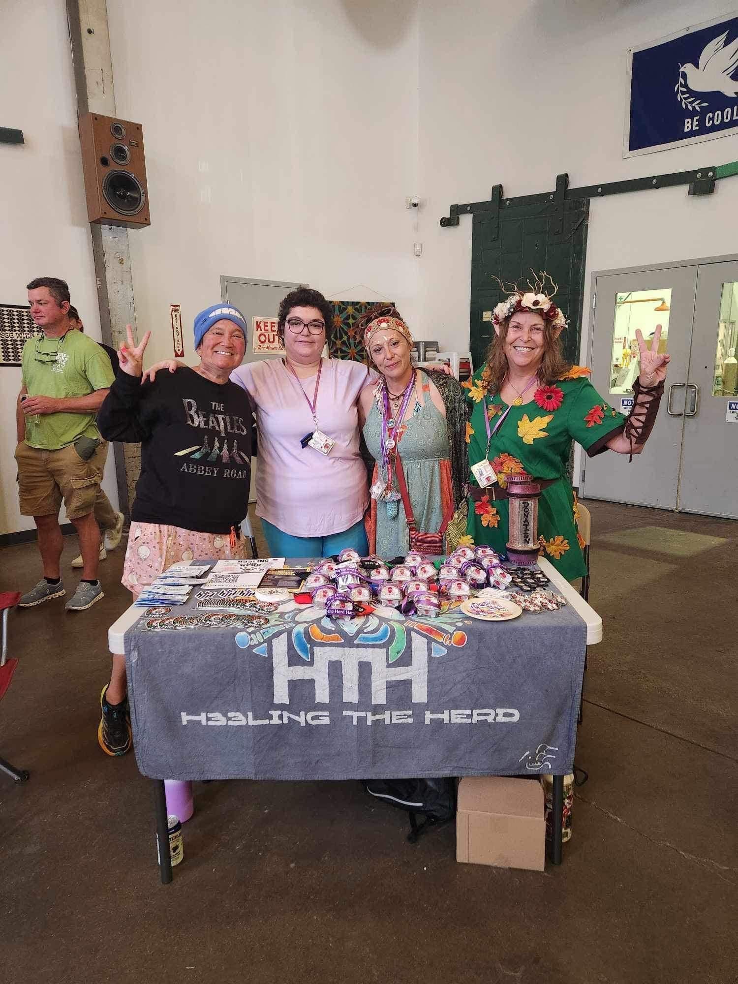 A group of women are posing for a picture in front of a table.