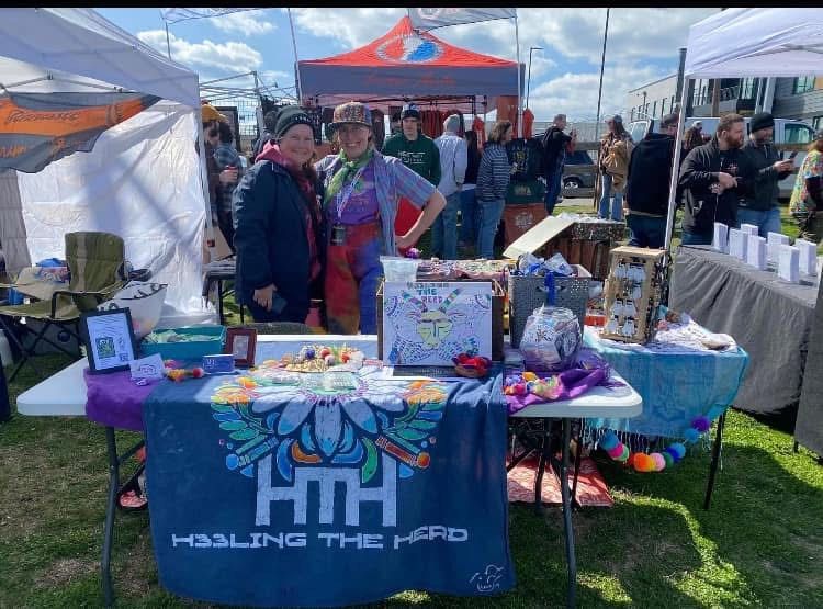 A group of people are standing around a table at a festival.