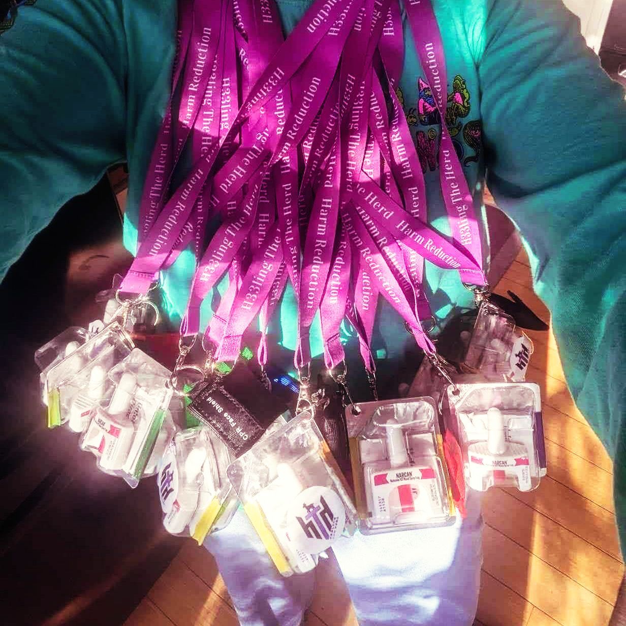 A person is holding a bunch of lanyards with purple ribbons