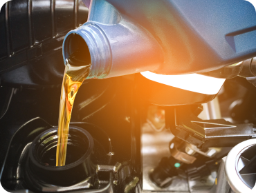 Pouring motor oil from a blue container into a car engine | Hornick's Diesel & Auto Repair