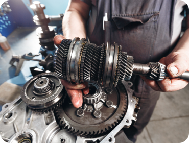 Mechanic holding a disassembled car transmission; gears visible | Hornick's Diesel & Auto Repair