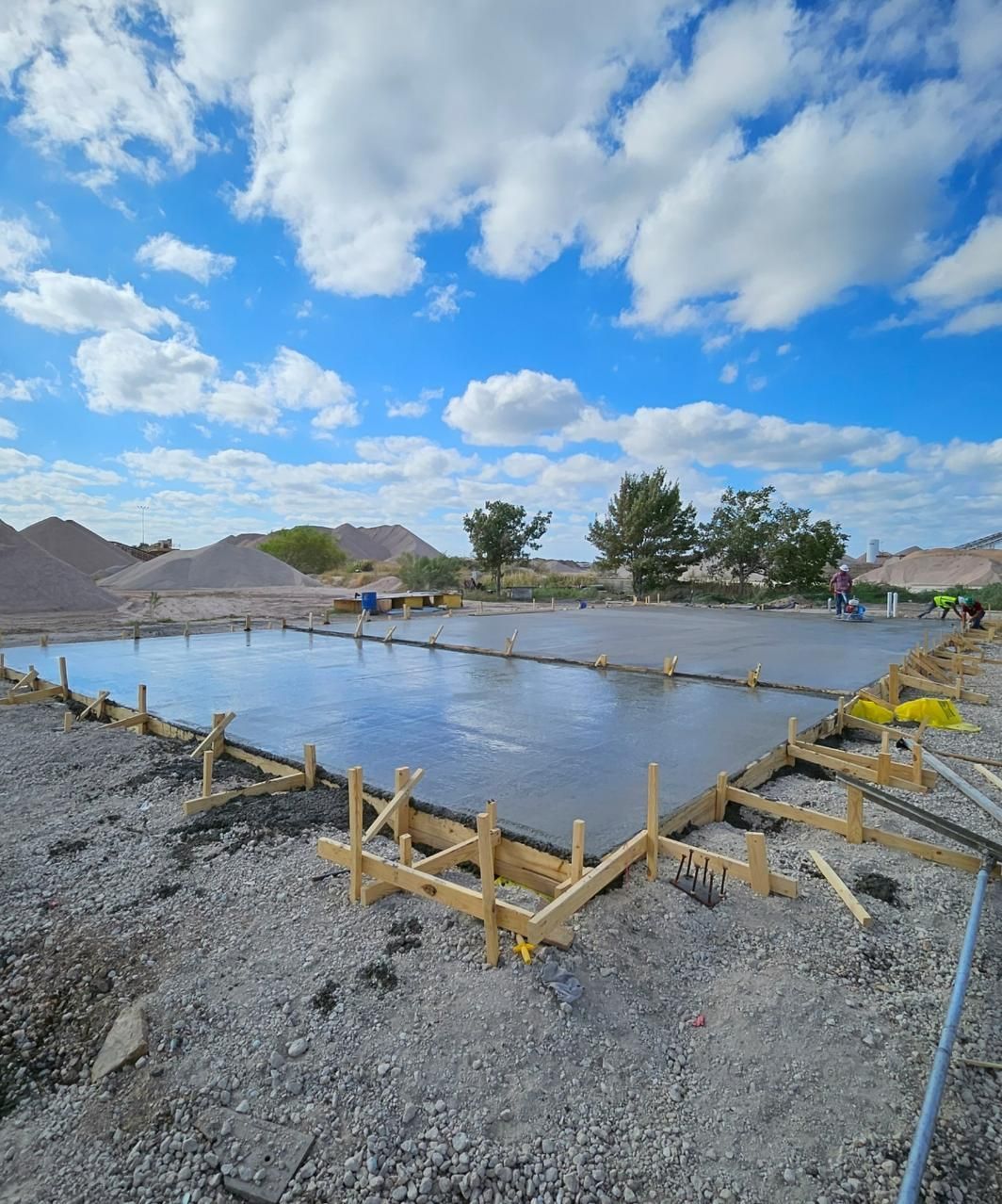 A large concrete slab is being poured on a construction site