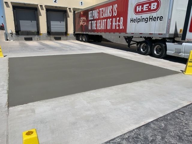 A h-e-b truck is parked in front of a warehouse
