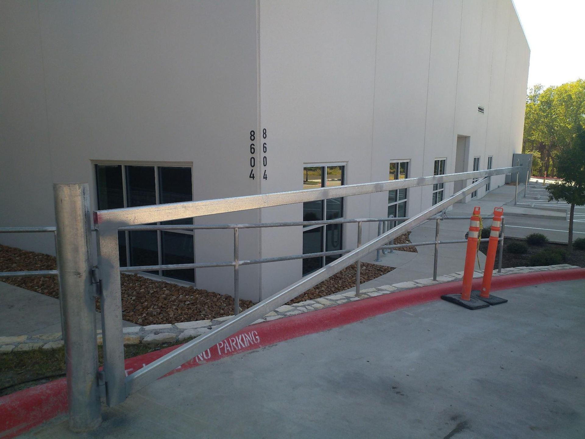 A metal gate is closed in front of a building.