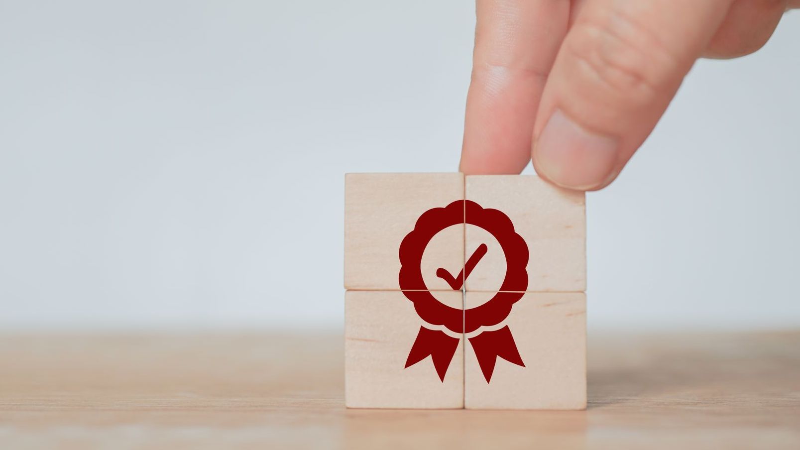 4 wooden blocks showing a certification symbol in red. 