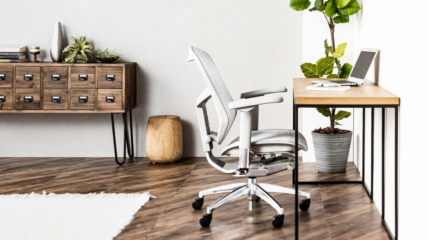 Grey frame office chair with mesh upholstery in front of a small desk in a home office