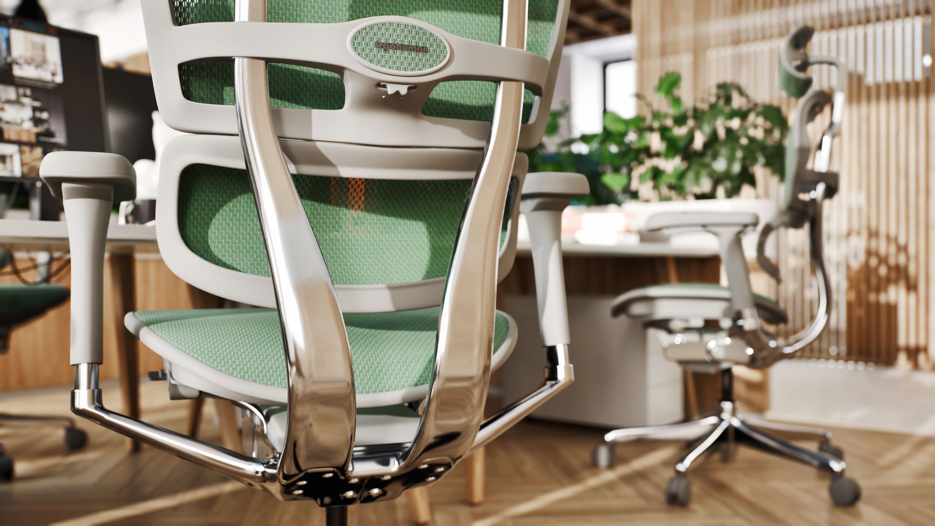 Close up of Ergohuman Elite ergonomic office chairs in grey frame with green mesh around a white desk table. The floor is herringbone wood. There are planters in the background