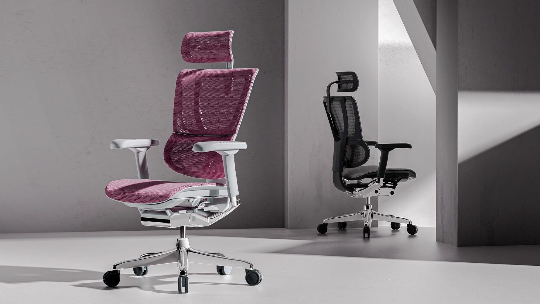 Two Mirus Elite chairs in an empty stylish warehouse. One is a grey frame with pink mesh, and the other is black with black mesh. 
