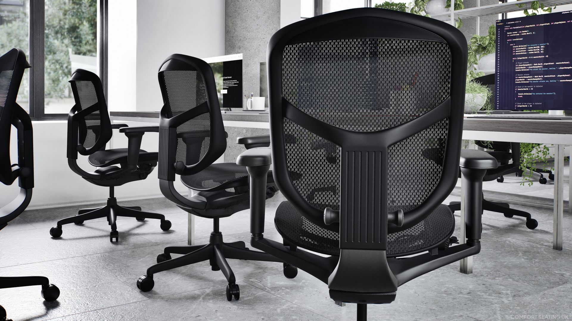 Black mesh office chairs sit at a row of desks in a modern office