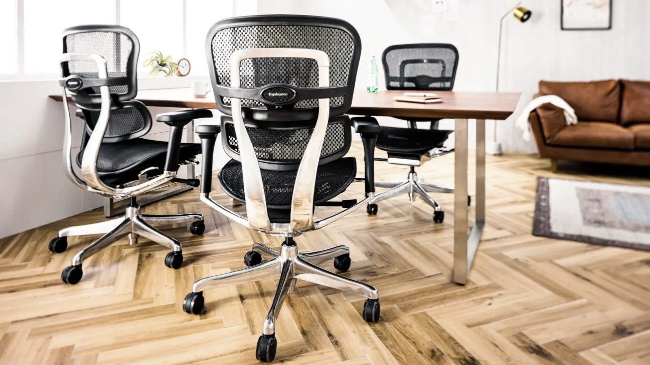 black ergohuman chairs with black mesh at a wooden desk