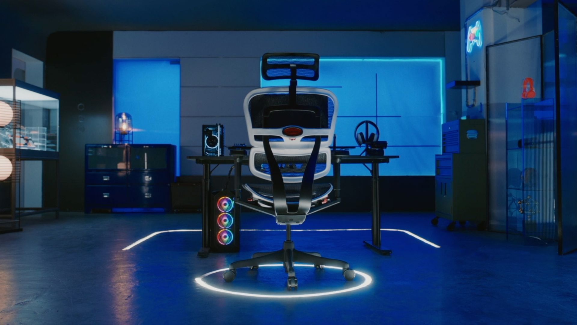 White Ergohuman Ultra gaming chair in the middle of a dark room with blue LED lighting. The chair is situated at a black desk. In the background of the room are cabinets and drawers, and two large transclucent windows with blue lights. 