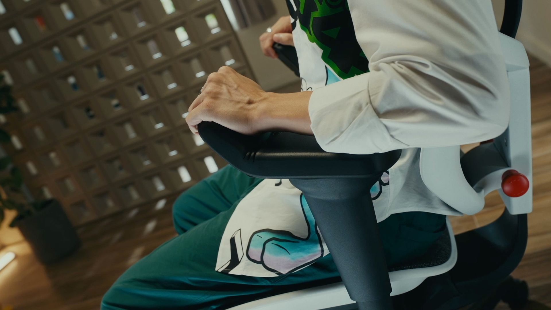 A man in a white jacket is adjusting the 5D armrests tilt on the white enjoy ultra gaming chair