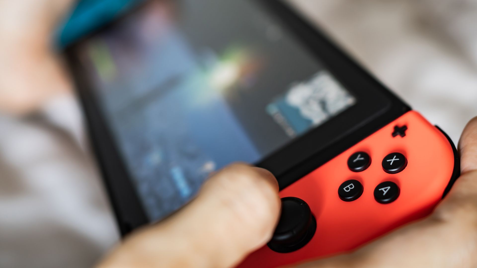 close up view of the nintendo switch with user's thumb operating joystick