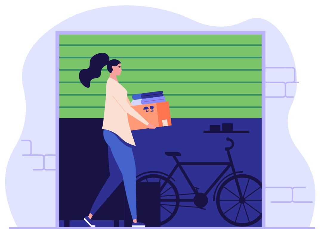 A woman is carrying a box in a garage next to a bicycle.