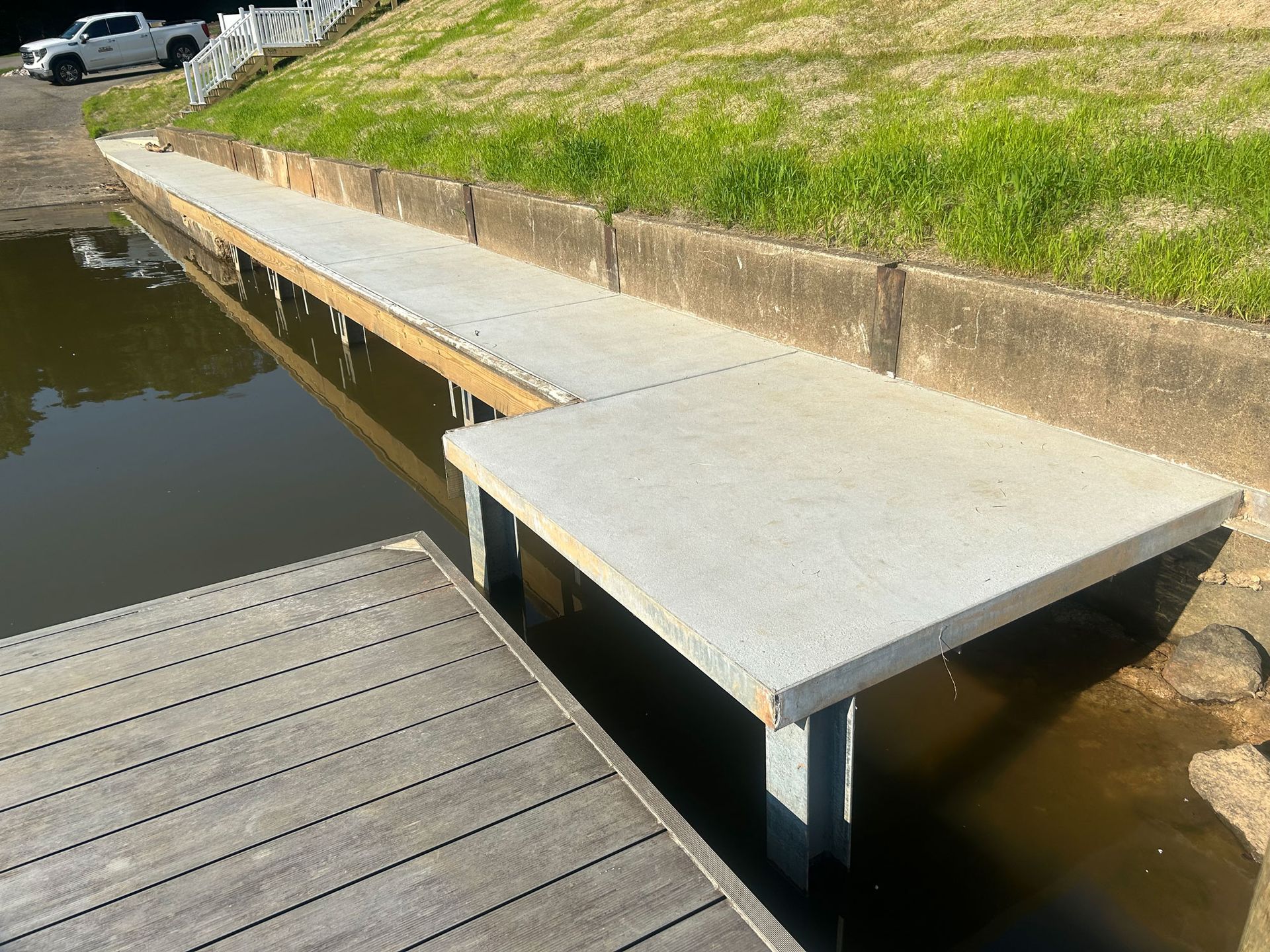 Construction workers pouring concrete floor from a truck. Steel rebar grid visible, yellow safety vests.