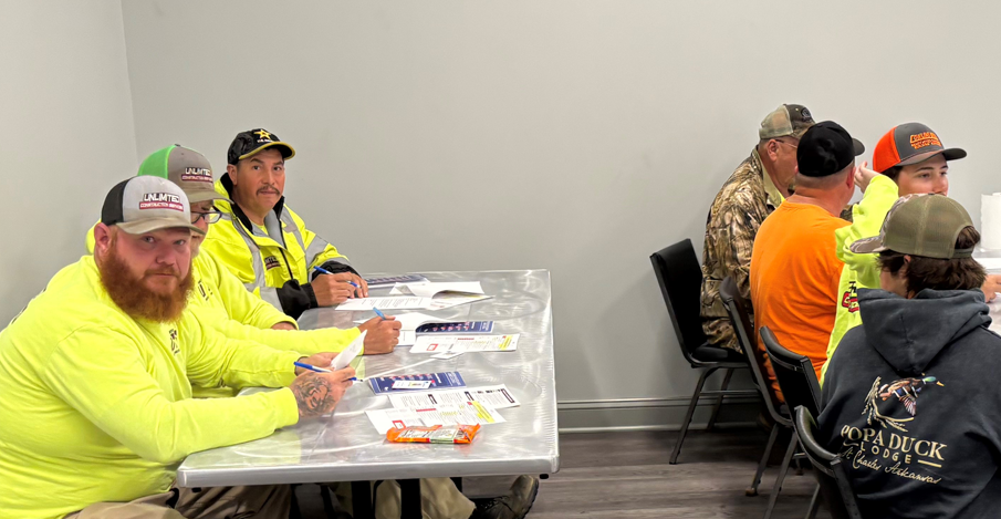 A group of men are sitting at a table in a room.