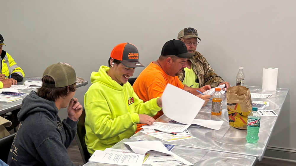A group of people are sitting at a table looking at papers.