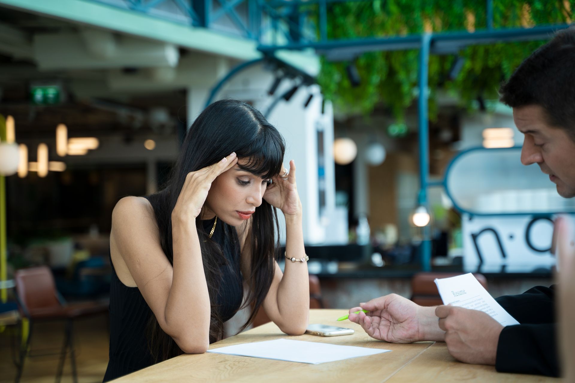 A man and a woman are sitting at a table looking at a piece of paper.