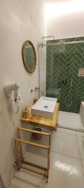 un bagno con lavabo , doccia e specchio .