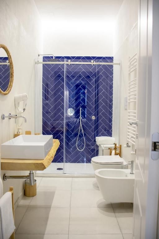 un bagno con lavandino , wc , bidet e doccia .