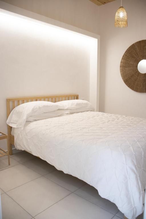 una camera da letto con un letto bianco e una lampada a sospensione .