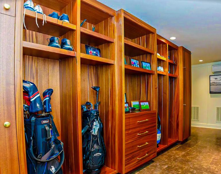 A closet filled with golf bags , clubs , and shoes.