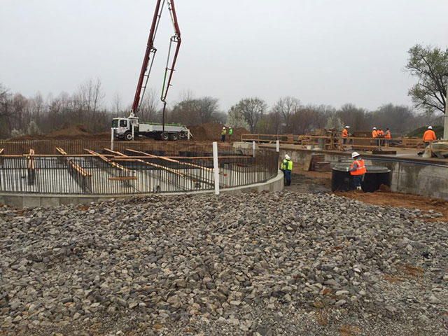 A concrete pump is being used to pour concrete on a construction site
