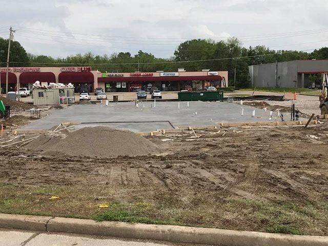 A construction site with a building in the background.
