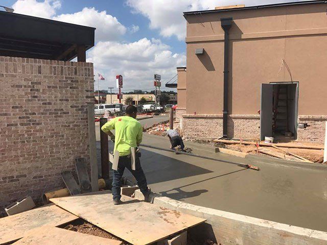 A man is standing on a wooden board in front of a building.