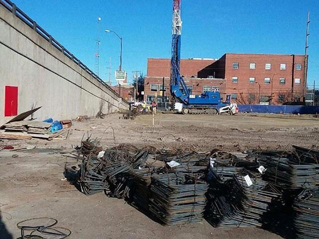 A construction site with a brick building in the background
