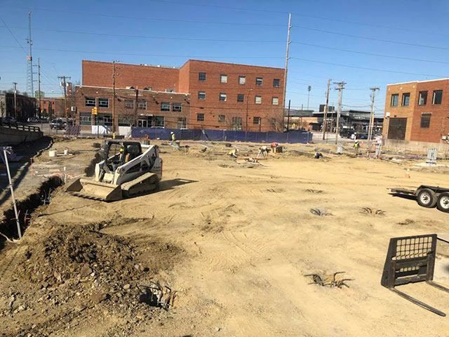 A bulldozer is digging a hole in a dirt field.
