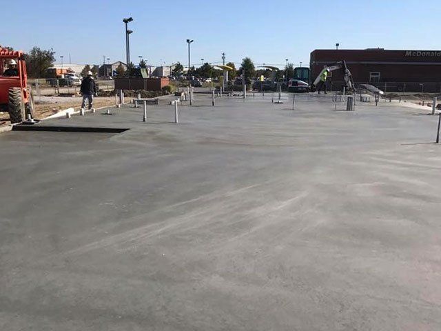 A concrete floor is being poured in a parking lot