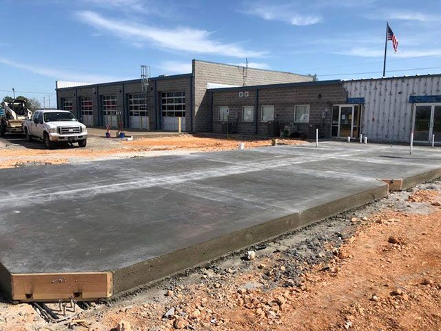 A concrete driveway is being built in front of a building.