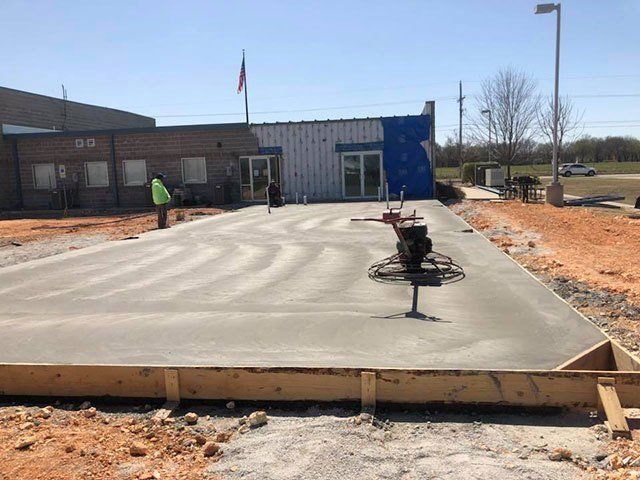 A concrete driveway is being built in front of a building.