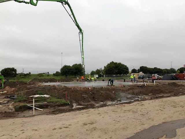 A concrete pump is being used to pour concrete on a construction site.